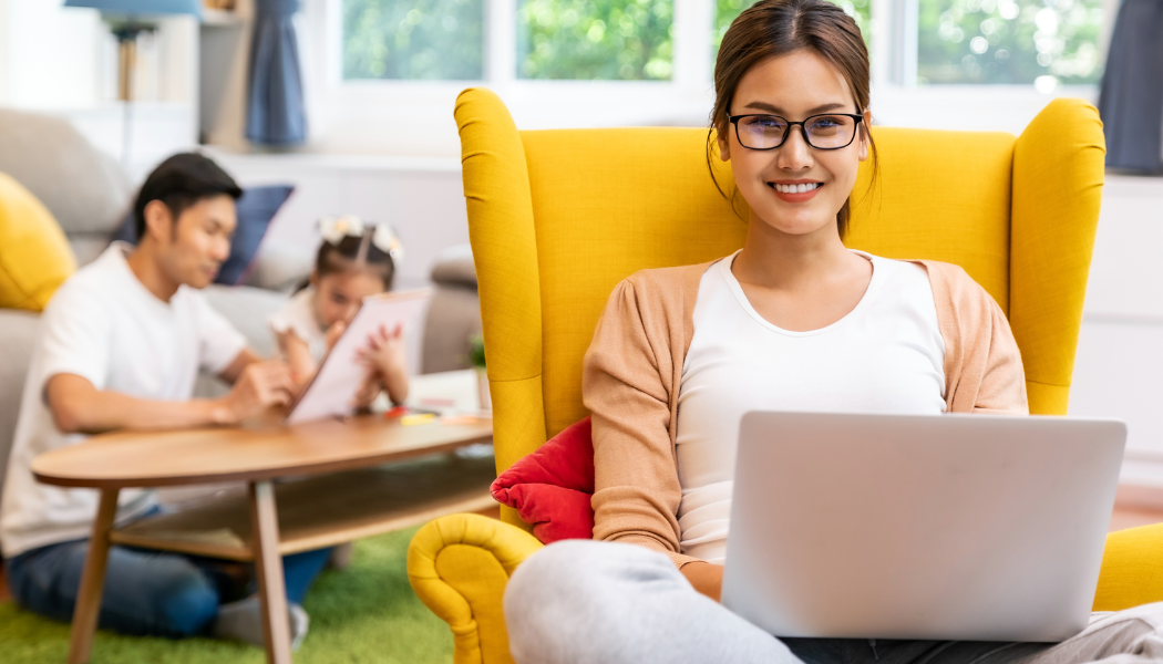 Lady working from home with her family playing in the background